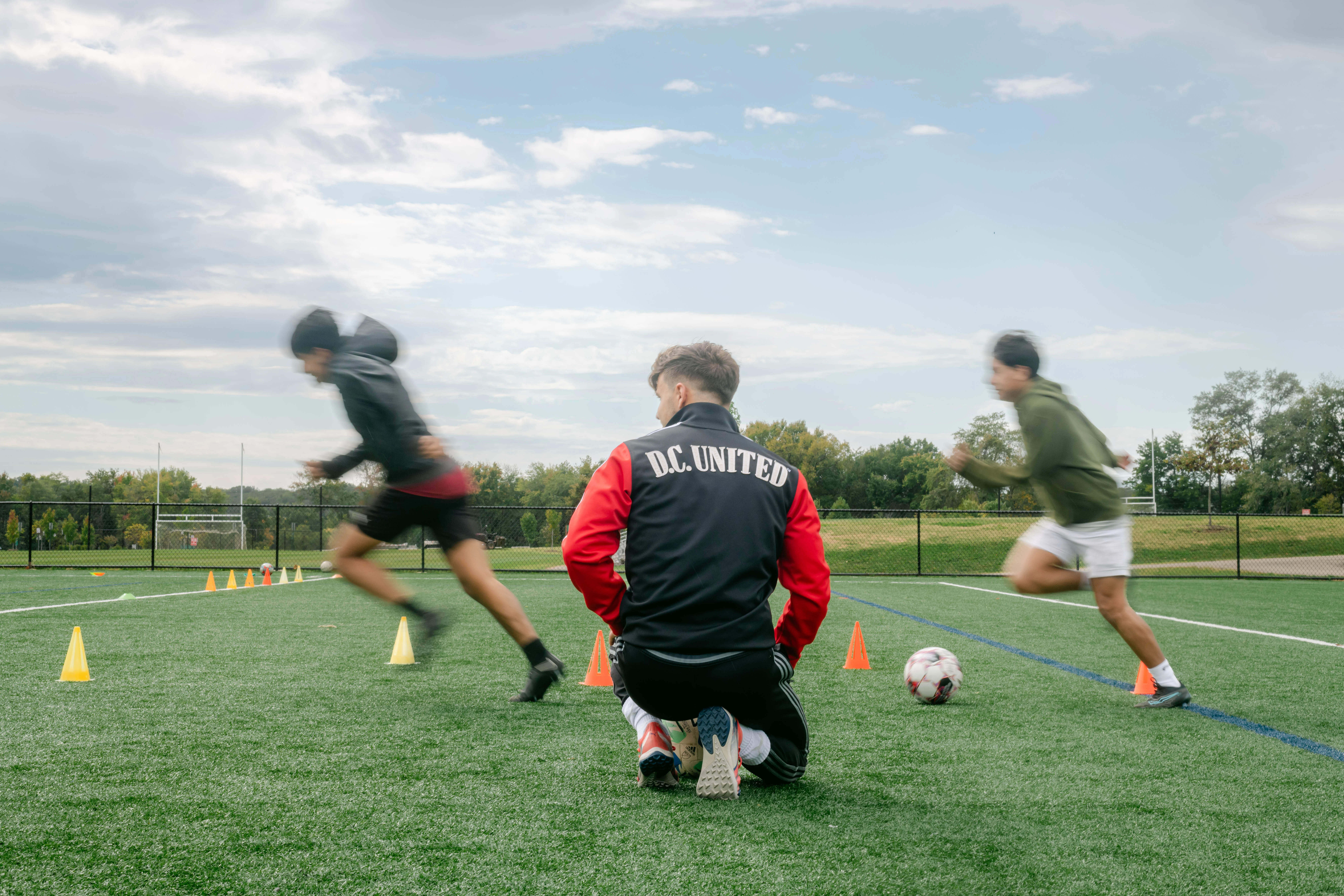 Coach training young soccer players on a green field in Warrenton, Virginia